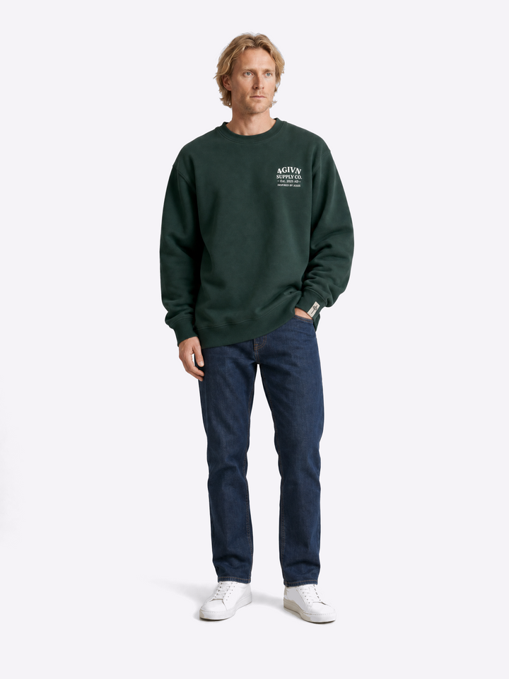 Mannelijk model draagt 4GIVN Signature Crew Pine Green sweater voorkant