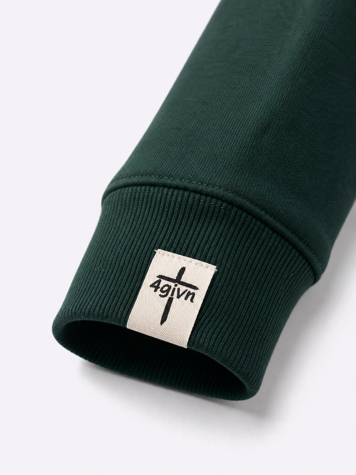 Detail van het 4GIVN mouwlabel op de Pine Green Signature Crew sweater